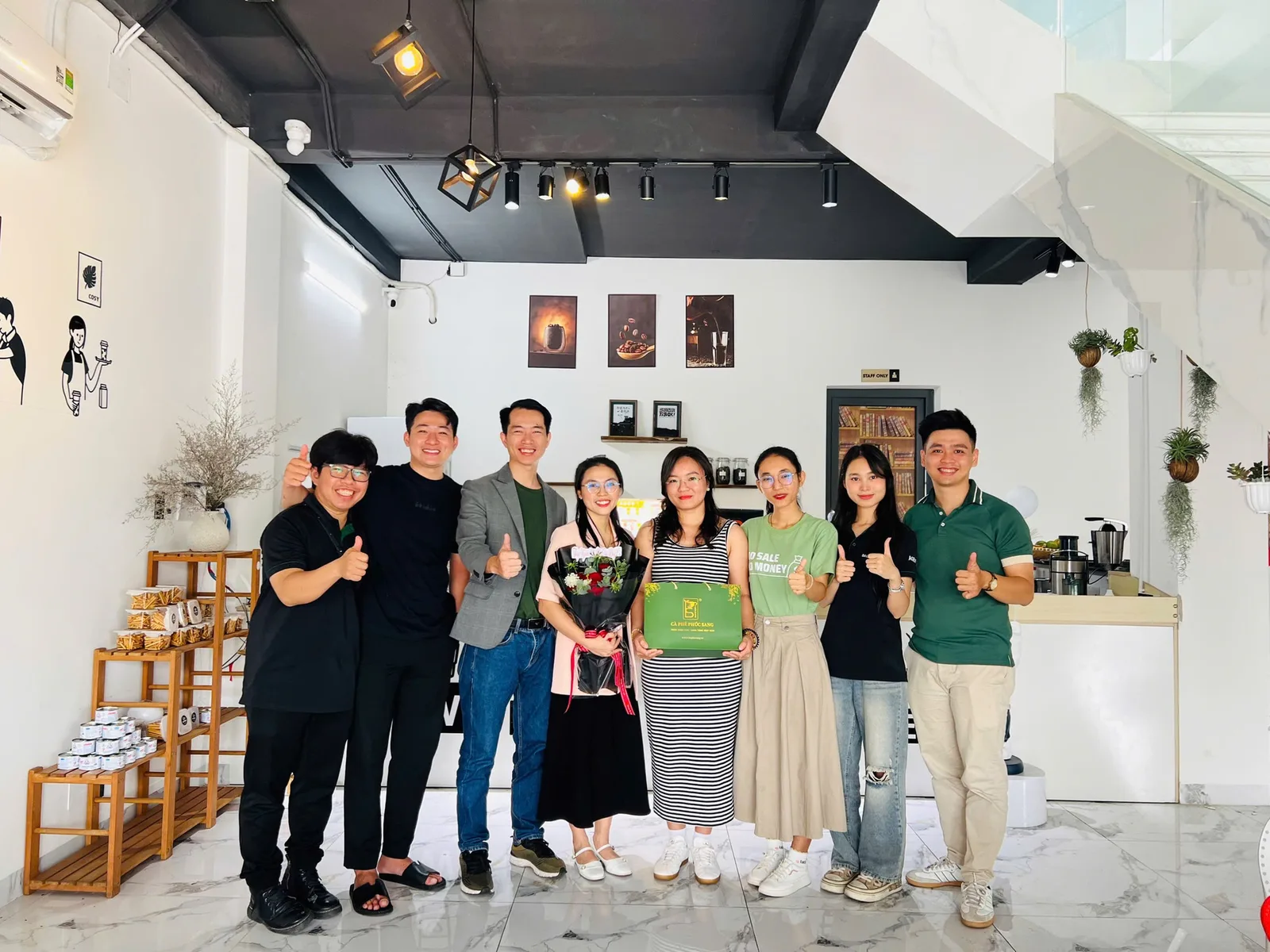 Học viên và đội ngũ học viện chụp chung trong quán cà phê mới mở