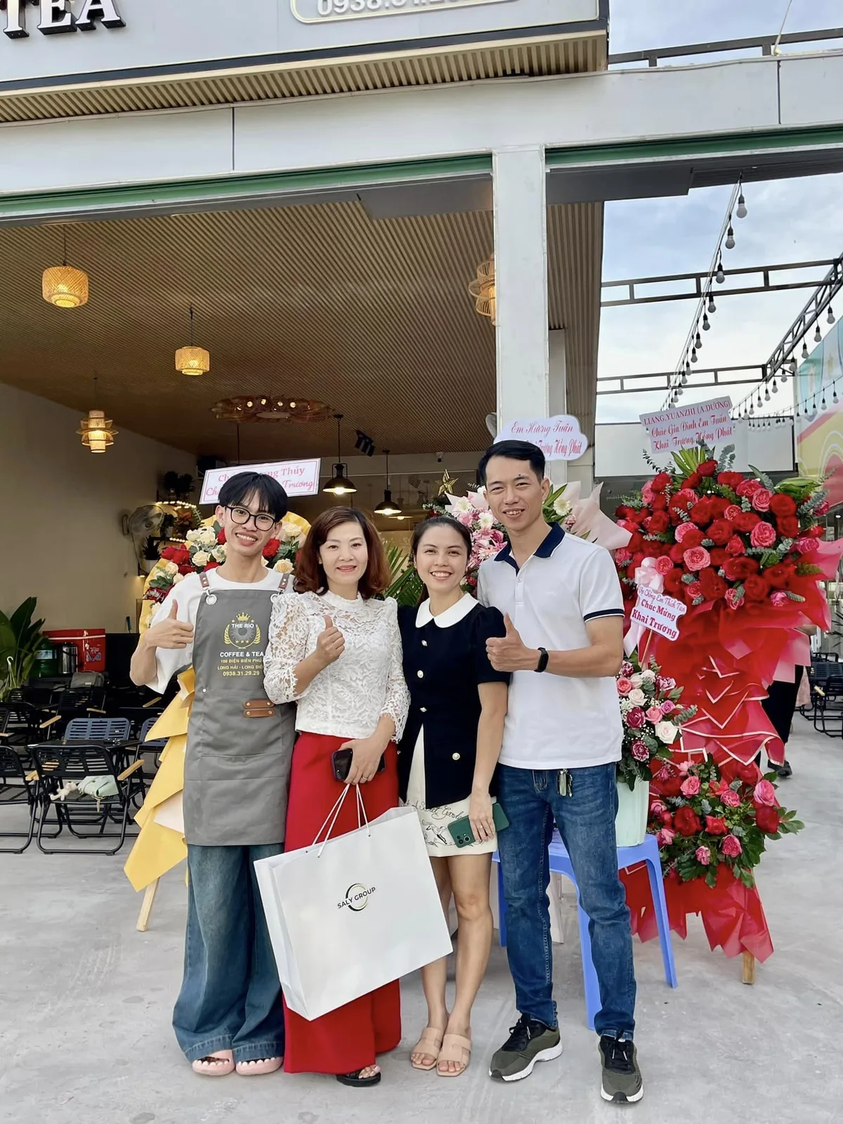 Học viên cùng gia đình trong ngày khai trương quán, hoa chúc mừng xếp hai bên