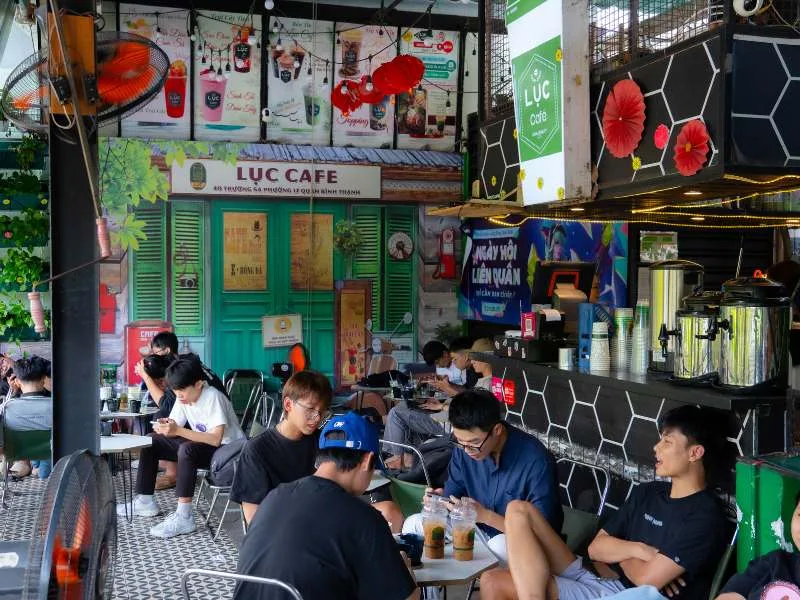 Quán Lục Cafe đông khách ngồi kín bàn phía trước, mô hình quán cà phê nhỏ